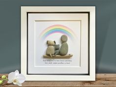 two stuffed bears sitting next to each other under a rainbow