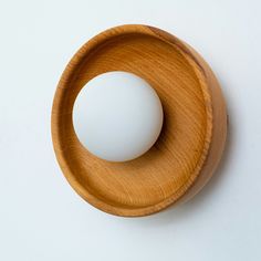 a wooden object with a white ball in the center on a white surface, viewed from above