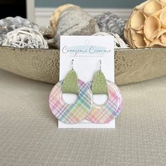 "These unique and fun spring plaid earrings are lightweight, featuring pearly white clay decorated with a pastel plaid design. Faux/vegan leather straps are threaded through the donut shaped clay pendants and used to attach them to earring wires. Clay is carefully hand mixed, decorated, molded, baked, sanded and sealed with high gloss resin before assembly. All creations are carefully crafted by hand, therefore no two items are identical. Slight variations in plaid patterns are to be expected. E Spring Casual Hypoallergenic Jewelry, Casual Hypoallergenic Jewelry For Spring, Casual Hypoallergenic Spring Jewelry, Pastel Jewelry For Spring Gift, Casual Everyday Spring Jewelry, Everyday Green Jewelry For Spring, Trendy Circle Earrings For Spring, Handmade Pastel Jewelry For Spring, Casual Dangle Jewelry For Spring