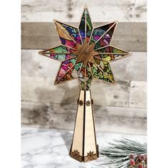 a multicolored stained glass star ornament sitting on top of a table