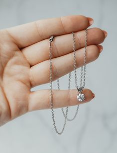 There's something classic and luxurious about a high quality single diamond hanging around your neck. This diamond solitaire pendant necklace is made from solid platinum and measures 18" long. The diamond is GIA certified as an all-natural .92ct G/VS2 round brilliant cut diamond securely set in a four prong basket style setting. This necklace comes with the GIA certificate and a free official appraisal showing the value of the necklace at $9650. Platinum Necklace, Diamond Solitaire Pendant, Gia Certificate, Basket Style, Solitaire Pendant Necklace, Solitaire Diamond, Solitaire Pendant, Brilliant Diamond, Round Brilliant Cut Diamond