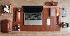 an overhead view of a desk with a laptop, phone and other items on it