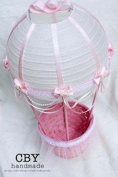 a white and pink basket with ribbon around it