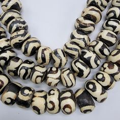 two strands of black and white beads on a white surface