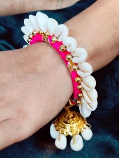 a close up of a person's arm wearing a bracelet with shells on it