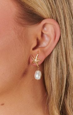 Check out Faithy Jewels Seaside Earrings ~ Gold/Pearl. Get $10 off + free shipping with Club Mumu. Elegant Starfish Charm Jewelry For Vacation, Elegant Starfish Shaped Jewelry For Vacation, Elegant Starfish Jewelry For Vacation, Single Drop Earring For Vacation, Starfish Jewelry For Vacation, Single Dangle Earring For Beach, Dangle Earrings With Ear Wire For Vacation, Gold Dangle Earrings For Beach Season, Elegant Summer Jewelry With Starfish Charm