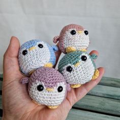 four small crocheted birds sitting on top of each other in someone's hand