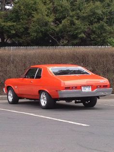 an orange car is parked in a parking lot