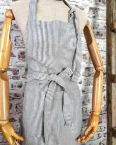 a mannequin with wooden arms and legs wearing an apron