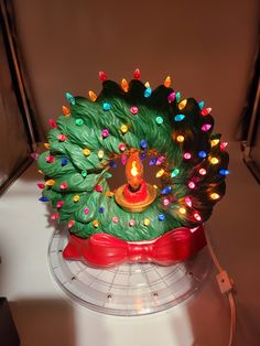 a lit up christmas tree decoration sitting on top of a table