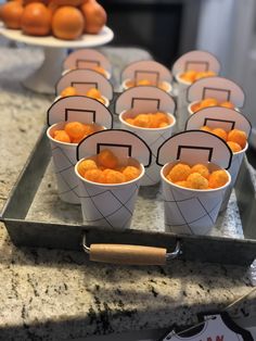 small cups filled with oranges sitting on top of a counter