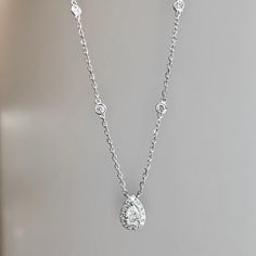 One (1) 14K white gold diamond pear shape halo necklace 55/100CTW prong set with (1) pear shape diamond 25/100CT of fine (G-H) color and (SI) clarity surrounded by (14) round brilliant cut diamond of fine (G-H) color and (VS) clarity with (4) bezel set round brilliant cut in the 18inch chain with a lobster clasp 30/100CTW. Pear Shaped Diamond Necklace, Halo Necklace, Diamond Bar, Pear Shaped Diamond, Diamond Halo, Round Brilliant Cut Diamond, Pear Shape, Brilliant Cut Diamond, Bezel Setting