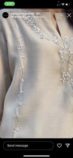 a woman's white blouse with beading on it