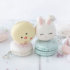 there are two small stuffed animals on top of macaroons