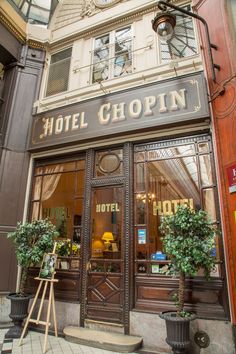 a hotel shop front with potted plants outside