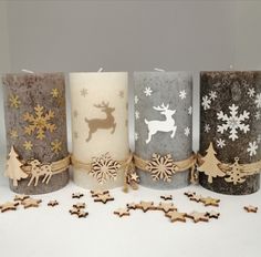 three candles with christmas decorations on them and one candle has reindeers, snowflakes, and stars around it