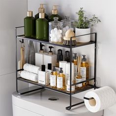 a bathroom shelf filled with lots of toiletries next to a white toilet paper roll