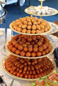 three tiered trays filled with food on top of a table