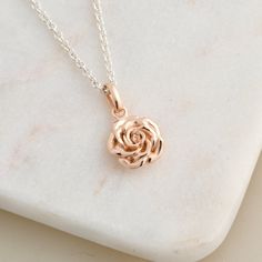 A simple wild rose that's an easy floral pendant & gift of love.  Made from solid silver with 18ct rose gold plated pendant on a shiny silver chain. The most romantic of flowers the red rose is 'the ambassador of love', - this necklace comes with a meaning card inside the gift box. How it's made: Perfectly made solid silver flower jewelry cast using a traditional loss wax technique, this elegant floral necklace has gently rounded petals, light and easy to wear at any age. The chain is a lightweight solid silver trace chain with a secure lobster clasp, and comes in a choice of lengths to suit you.  Each necklace is wrapped in acid-free tissue paper and presented in a gift box with a rose meaning card.   Dimensions: Rose Pendant: 9mm high x 10mm wide x 3.5mm deep Necklace: 1.1mm wide Solid Gold Pendant Necklace, Rose Gold Charm Necklace With Flower Pendant, Rose Gold Necklace With Rose Design For Gift, Rose Flower Pendant Charm Necklace, Rose Colored Sterling Silver Necklace With Rose Design, Rose Colored Jewelry With Round Rose Pendant, Rose Sterling Silver Necklace With Rose Design, Rose Colored Jewelry With Round Rose Design Pendant, Sterling Silver Rose Necklace With Rose Design