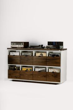 the sideboard is made out of wood and has many compartments for cd's