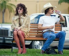 a man and woman sitting on a park bench