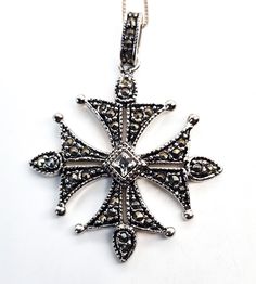 Maltese cross marcasite and rhinestone silver plated necklace. Good used condition with little to no signs of wear. No missing marcasite stones. Comes with sterling silver box chain. Necklace measures 19 inches long. Pendant measures 1 and 3/4ths of an inch tall and 1 and 1/4 of an inch wide. Antique Sterling Silver Cross Pendant Necklace, Ornate Silver Cross Pendant Necklace, Vintage Silver Sterling Silver Cross Necklace, Vintage Sterling Silver Cross Necklace, Antique Silver Cross Necklace Gift, Ornate Silver Cross Necklace, Antique Silver Cross Necklace As Gift, Antique Silver Cross Necklace For Gift, Antique Silver Cross Pendant Necklace