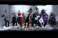 a window display with mannequins and christmas trees