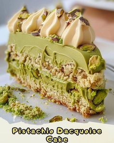 there is a piece of cake with green frosting on the top and some pistachio