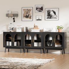 a black and gold sideboard with pictures on the wall