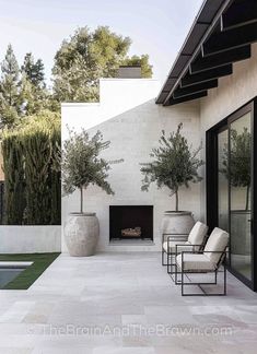 an outdoor living area with chairs and a fire place