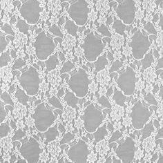 a white lace fabric with flowers and leaves on it, as well as a ruler