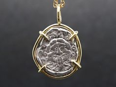 a gold and silver pendant with an image of jesus in the center, on a black background