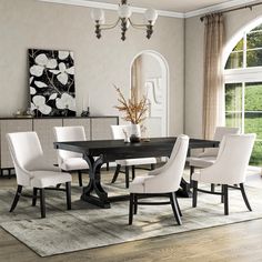 a dining room table with white chairs in front of a large window and an area rug on the floor