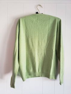 This is a vintage cardigan sweater. It is green, long sleeved and has Mother of Pearl buttons. I do not know its size as there is no label. Please refer to the measurements for a proper fit. I think this sweater is possibly lambswool or angora. I am not sure due to the missing label. Please note, there are 2 or 3 spots that are a bit dark. I dont think these are stains, just little dark marks in the fibers. They are evident in the 4th and 5th pictures. Please feel free to ask to see an image. Th Green Cotton Long Sleeve Cardigan, Green Long Sleeve Cardigan, Classic Green Cotton Cardigan, Green Cotton V-neck Cardigan, Vintage Green Cardigan For Fall, Green Crew Neck Cardigan For Fall, Classic Green Long Sleeve Cardigan, Classic Green Long Sleeve Sweater, Retro Green V-neck Sweater