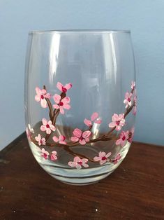 a glass with pink flowers painted on it