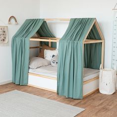 a child's bed with curtains on the top and bottom, in a white room