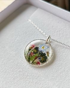 "Yorkshire forest real pressed flowers in a 22-24mm solid 925 sterling silver circle.  Hung on a solid sterling silver 925 chain stamped with certification.  This necklace symbolises spirituality, memories and represents new beginnings.  The flower is encapsulated in a crystal clear Resin which is Non-toxic, No VOCs, No fumes, No solvents, Non-flammable, Non-hazardous, No BPA.  A cute and eco friendly gift for yourself or a loved one. 🌼 So someone you love can bring spring with them wherever they go 🌼  The necklace comes in a lovely little box, hand stamped with the logo and will be posted in padded paper packaging.  🌿 Each necklace is one of a kind so may vary slightly as I have hand picked the flowers and hand made each one. 🌷🌷 Delivery:  Free Tracked and signed delivery to all coun Nature-inspired Round Birth Flower Necklaces, Nature-inspired Round Birth Flower Necklace, Round Nature-inspired Birth Flower Necklace, Sterling Silver Necklace With Natural Inclusions For Gift, Minimalist Sterling Silver Necklace With Pressed Flowers, Delicate Sterling Silver Round Disc Jewelry, Sterling Silver Delicate Round Disc Jewelry, Sterling Silver Round Disc Delicate Jewelry, Sterling Silver Birth Flower Necklace For Wedding