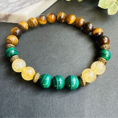 Unisex Stretch Beaded Bracelet Features 8mm Round Beads Made Of Natural Green Malachite, Yellow Citrine, And Brown Tigers Eye. The Combination Of These Three Stones Creates A Unique And Eye-Catching Design. The Stretchy Band Ensures A Comfortable Fit For Most Wrist Sizes. This Bracelet Is Perfect For Adding A Pop Of Color To Any Outfit And Makes A Great Gift For Any Jewelry Lover. Yellow Spiritual Jewelry With Gemstone Beads, Spiritual Yellow Jewelry With Gemstone Beads, Spiritual Yellow Gemstone Beads Jewelry, Yellow Beaded Bracelets With Round Beads For Everyday, Yellow Hand-strung Jewelry For Meditation, Yellow Round Bead Bracelets For Everyday, Yellow Round Beads Bracelet For Everyday, Yellow Beaded Bracelets For Everyday, Yellow Beaded Jewelry For Healing