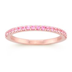 This utterly feminine wedding band features 19 round pavé-set pink sapphires at approximately .28 carat total weight. Each stone has been hand-selected for maximum color and sparkle. The ring is crafted from quality 14 karat rose gold. Pink Eternity Band With Prong Setting As Promise Ring, Pink Sapphire Stackable Ring In Fine Jewelry Style, Pink Sapphire Stackable Ring For Anniversary, Fine Jewelry Pink Sapphire Diamond Ring In Pink Gold, Fine Jewelry Pink Gold Diamond Ring With Pink Sapphire, Elegant Pink Sapphire Stackable Ring, Pink Diamond Ring With Round Band In Fine Jewelry, Pink Eternity Band With Prong Setting, Fine Jewelry Pink Diamond Ring With Round Band