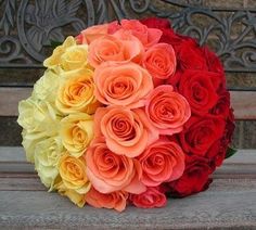 a bouquet of roses sitting on top of a wooden bench