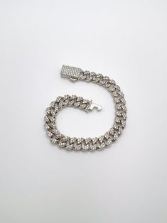 Description: Cuban chain bracelet encrusted with cubic zirconia. Material: Rhodium plated brass, 3A cubic zirconia Measurement: 7" length, 8mm width Tarnish resistant, water resistant, hypoallergenic Luxury Cuban Link Bracelet In Diamond White Cubic Zirconia, Luxury Diamond White Bracelets With Rhinestones, Silver Diamond Chain Bracelets, Luxury White Gold Bracelets With Rhinestones, Luxury White Gold Bracelet With Rhinestones, Elegant White Gold Cuban Link Bracelet With Cubic Zirconia, Luxury Cuban Link Bracelet In Diamond White, Luxury Iced-out Cubic Zirconia Chain Bracelet, Cuban Link White Gold Chain Bracelet With Diamond Accents