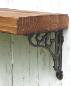 a wooden shelf sitting on top of a white wall