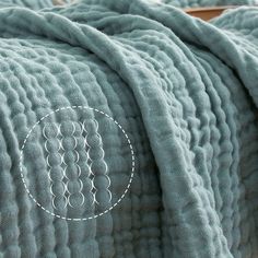 a close up of a blanket on a bed with circles drawn in the middle and an embroidered circle at the center