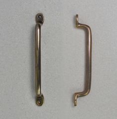 two metal handles on a white surface one has a screw and the other is a handle