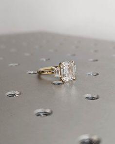 a diamond ring sitting on top of a metal surface