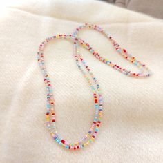 "This is a one strand beaded multi color necklace, with NO CLASP, and can be worn in multiple ways, as shown in pictures. Matching bracelet found here: https://www.etsy.com/listing/1037602923/pink-and-yellow-beaded-bracelet ❤ SIZES This item is one size fits all. ❤ PROCESSING AND SHIPPING Most orders are made and shipped out in one business day. Please check delivery timeframes for your location on the description below. ❤ CUSTOM ORDERS If you like this item in a different color, send me a messa Summer Multi-strand Colorful Beaded Necklaces, Adjustable Tiny Beads Lariat Necklace, Adjustable Lariat Necklace With Tiny Beads, Colorful Beads Lariat Necklace For Beach, Delicate Beaded Necklaces For Jewelry Making, Handmade Dainty Beaded Necklaces For Summer, Dainty Handmade Beaded Necklaces For Summer, Dainty Single Strand Necklaces With Round Beads, Dainty Single Strand Necklace With Round Beads