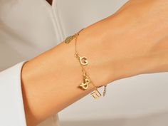 A Letter Charm Bracelet in 14k Gold is a personalized and stylish accessory that holds sentimental value. This bracelet features individual charms crafted from high-quality 14k gold, showcasing a radiant and timeless elegance. The charms are intricately designed in the form of letters, allowing for personalized combinations that can spell out names, initials, or meaningful words. FEATURES • Made to Order • Gold Kt: 14k Solid Gold, 18k Solid Gold • Gold Color: Rose Gold, Yellow Gold, White Gold • Gold Symbolic Charm Bracelet, Symbolic Gold Charm Bracelet, Elegant Adjustable Initials Charm Bracelet, Elegant Sterling Silver Charm Bracelet For Personalized Gift, Elegant Engraved Charm Bracelet, Dainty Yellow Gold Name Bracelet With Initials, Personalized 14k Gold Charm Bracelet For Anniversary, Dainty Personalized 14k Gold Charm Bracelet, Yellow Gold Charm Bracelet Fine Jewelry