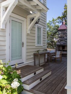 an outdoor patio with steps leading up to the front door and table on the deck