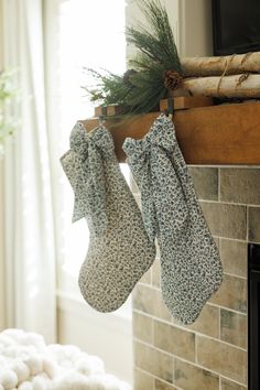 two stockings hanging from a fireplace mantel