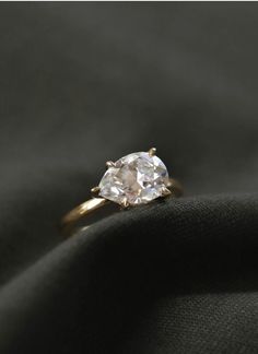 a diamond ring sitting on top of a black cloth